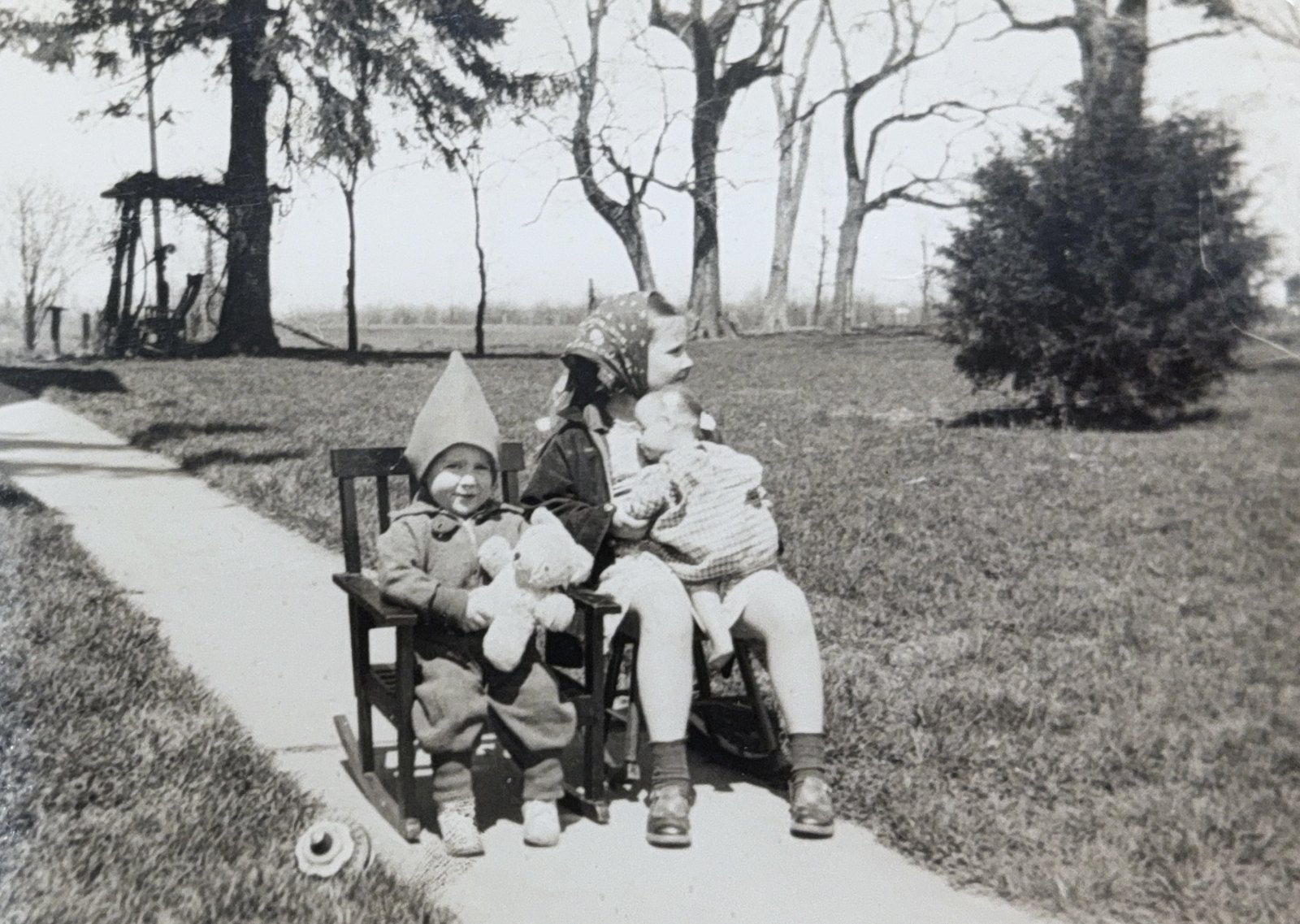 Three small children on a wagon along a farm walk